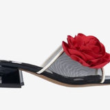 Black heel with a red flower and white/transparent strap close-up