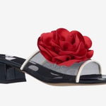 Black heel with a red flower and white/transparent strap side view