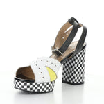 High-heeled platform shoe with checkered heel and yellow/white toe strap front view