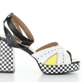High-heeled platform shoe with checkered heel and yellow/white toe strap close-up
