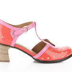 Red polka dot shoe with pink strap and buckle closure close-up
