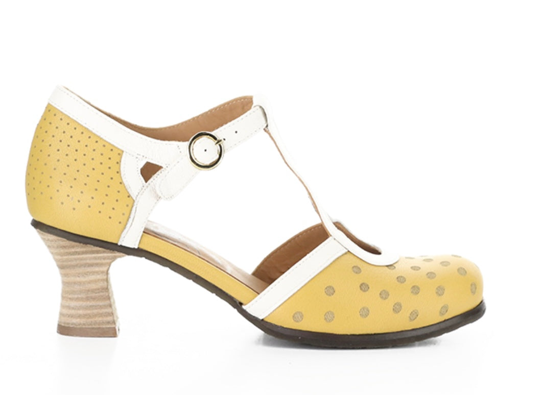 Yellow polka-dot shoe with white straps and buckle closure close-up