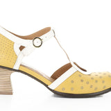 Yellow polka-dot shoe with white straps and buckle closure close-up