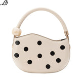 Off-white handbag with black polka dots and pearl handle close-up