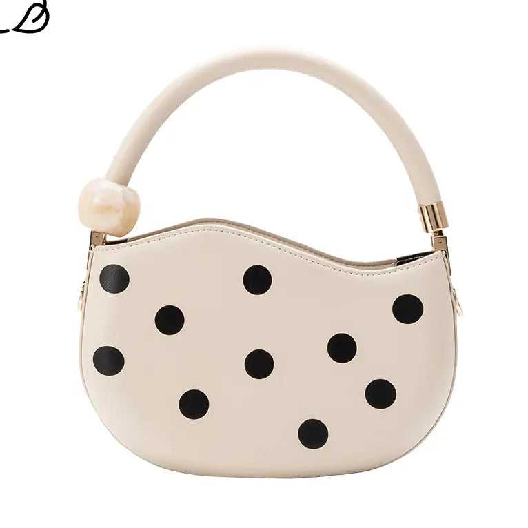 Off-white handbag with black polka dots and pearl handle close-up