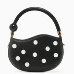 Black round handbag with white polka dots