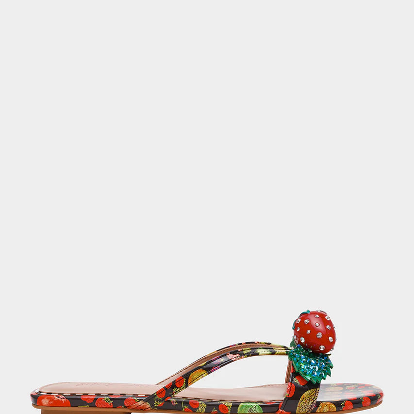 Colorful sandal with a decorative strawberry on toe strap close-up