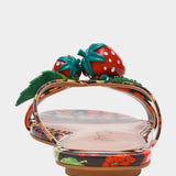 Colorful sandal with a decorative strawberry on toe strap heel view