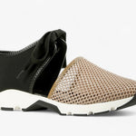 Black sneaker with beige mesh toe box with a white sole close-up