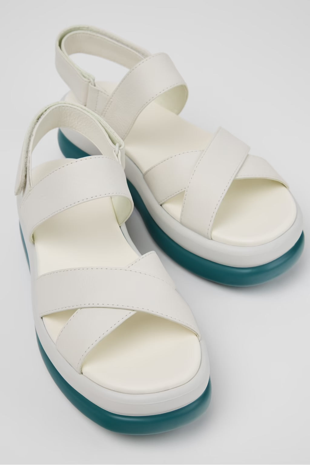 White platform sandal with a blue-green sole and multiple straps pair 