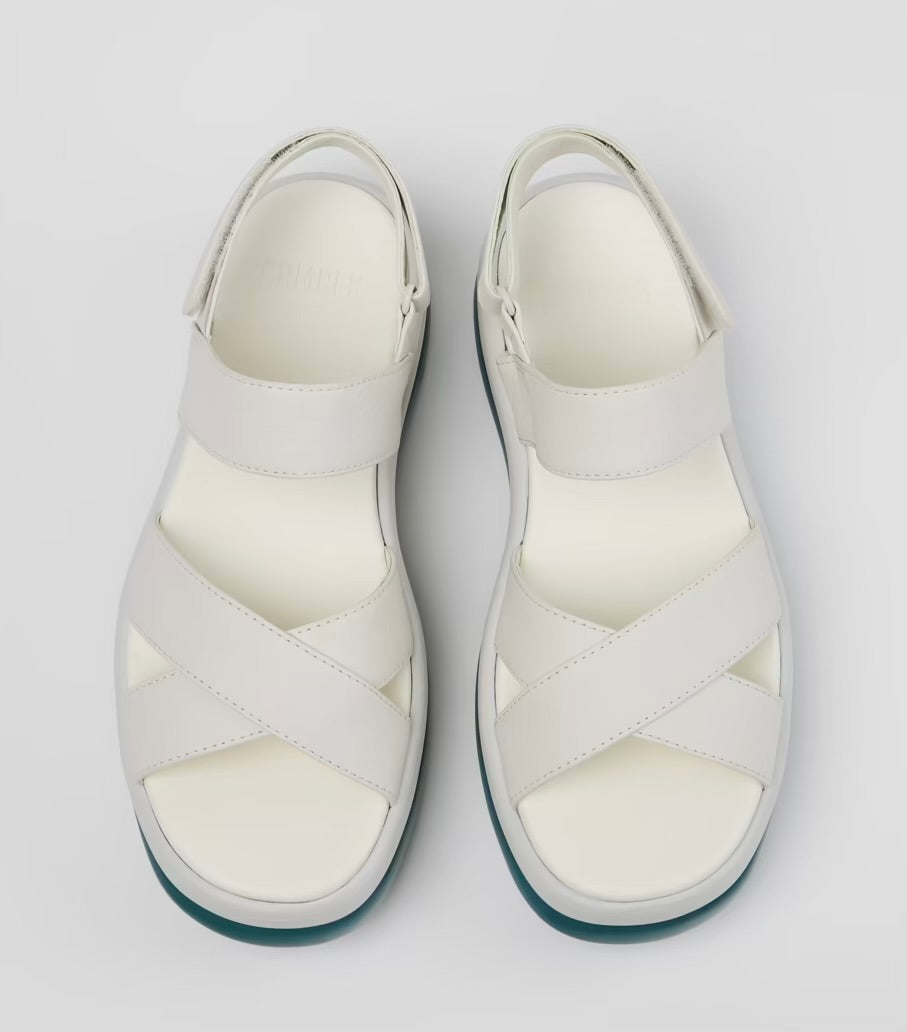 White platform sandal with a blue-green sole and multiple straps pair birds eye view