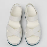 White platform sandal with a blue-green sole and multiple straps pair birds eye view