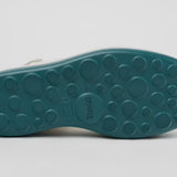White platform sandal with a blue-green sole and multiple straps from bottom