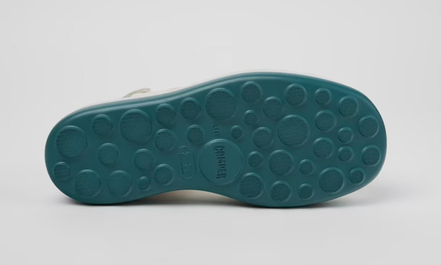 White platform sandal with a blue-green sole and multiple straps from bottom