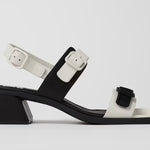 Black and white modern sandal with a block heel and buckle straps close up