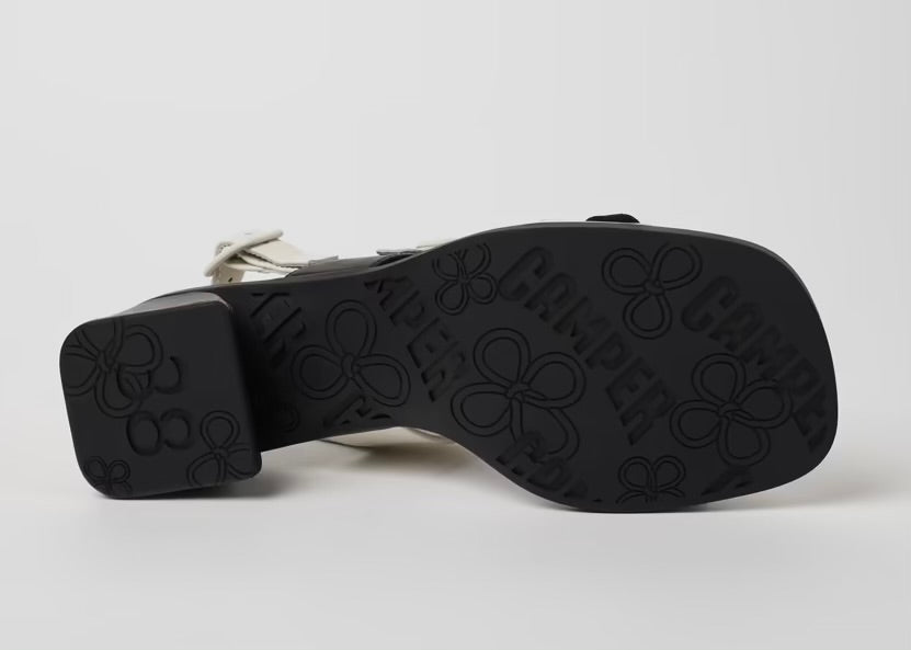 Black and white modern sandal with a block heel and buckle straps bottom