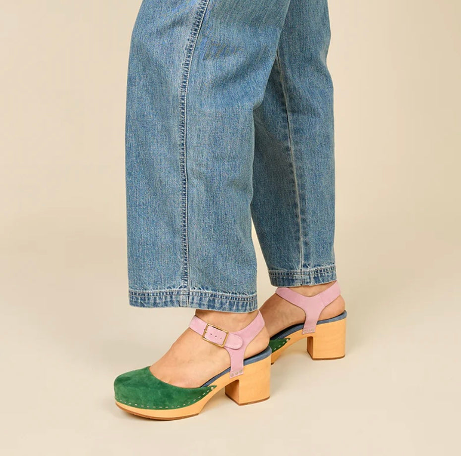 Green and blue suede clog shoe with pink strap with gold strap, and wooden sole pair on model standing