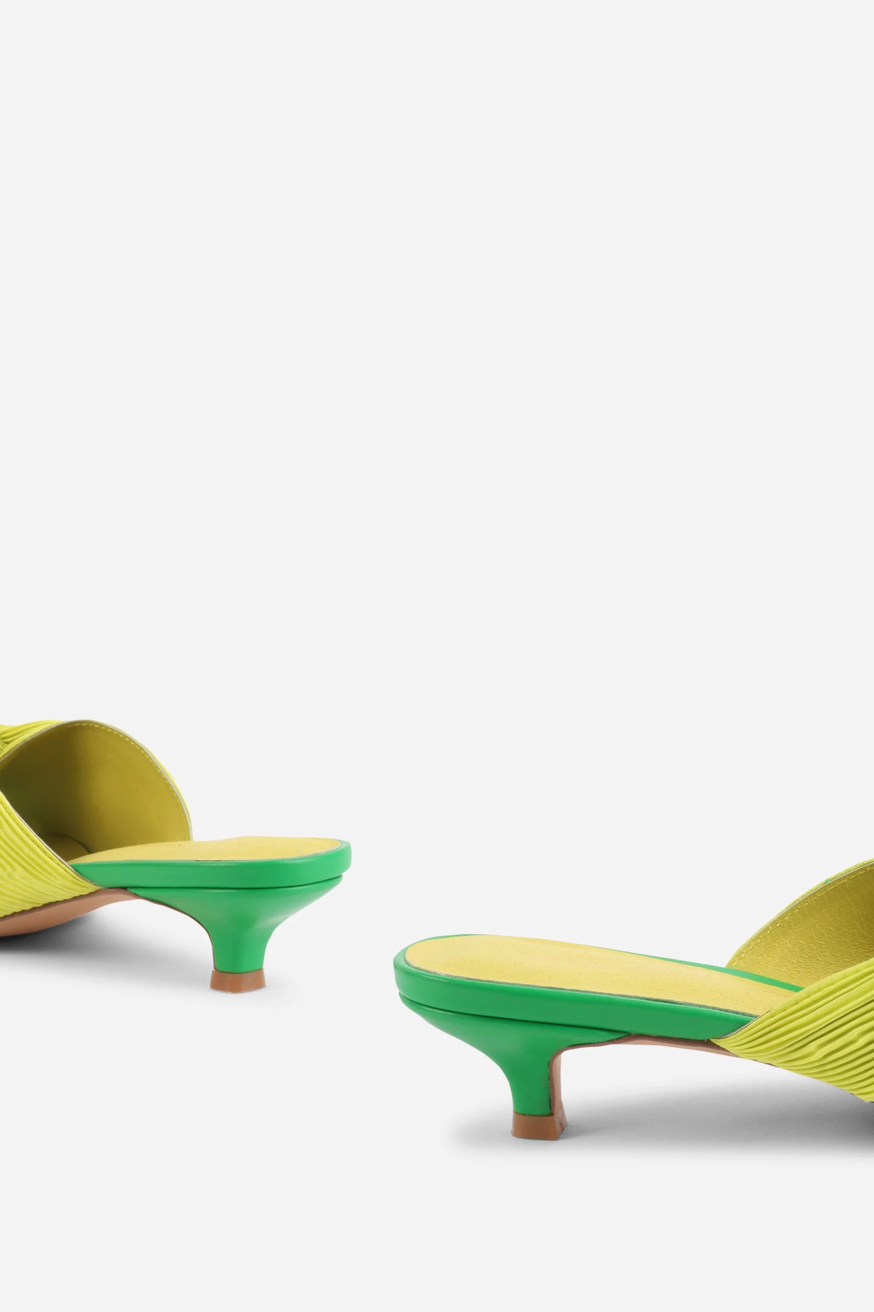 Yellow pleated kitten pen back sandal with a green heel pair close up on heel