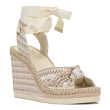 Beige wedge sandal with raffia details on a white background