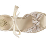Beige sandal with woven design and bow on a white background
