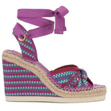 Woven wedge sandal with a purple strap on a white background