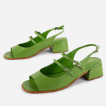 Green high-heeled sandals on a white background