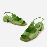 Green high-heeled shoes with open toes and thin straps on a white background