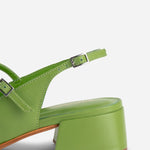 Green sandal with a block heel on a white background