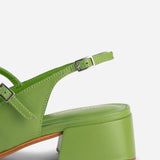 Green sandal with a block heel on a white background