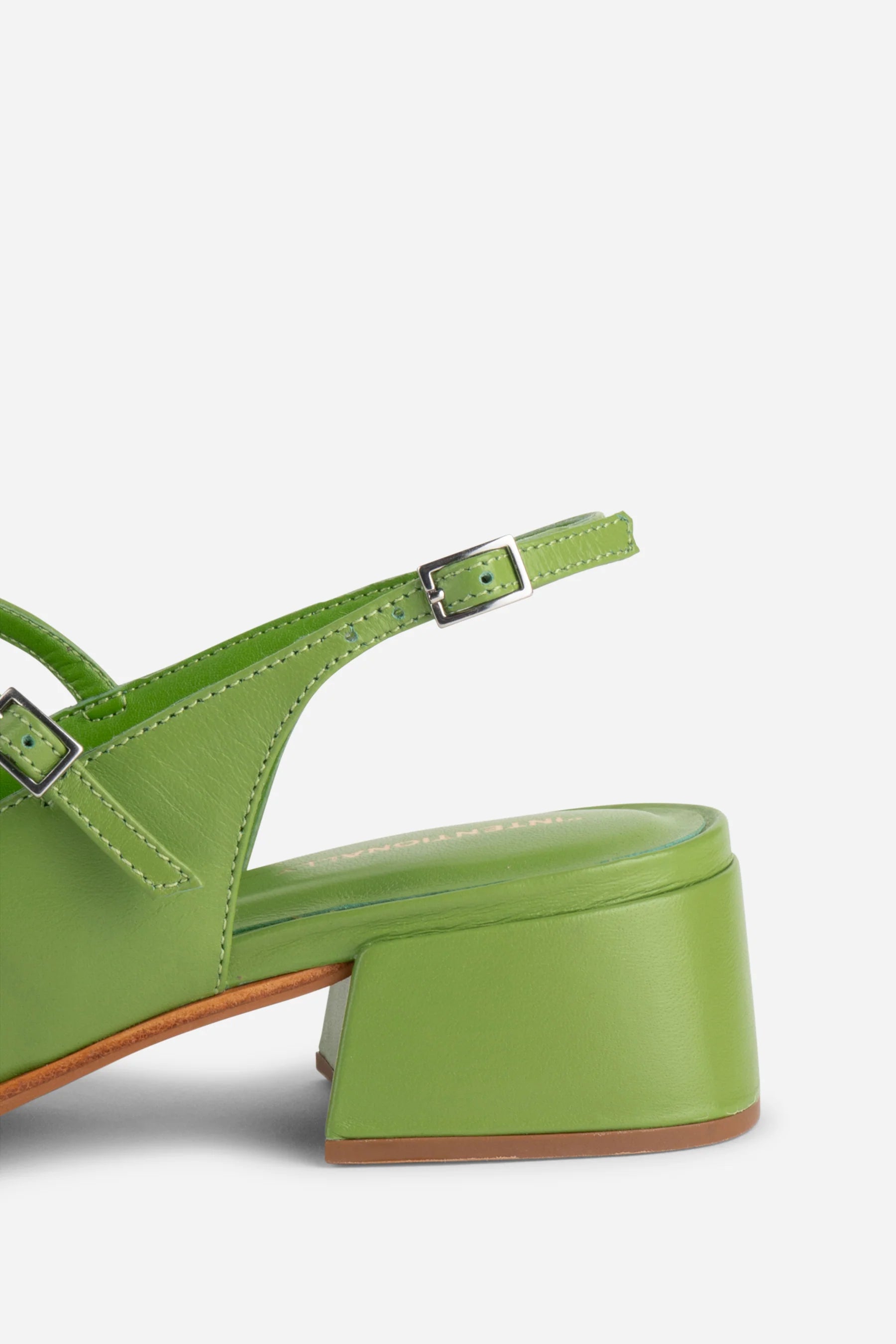 Green sandal with a block heel on a white background