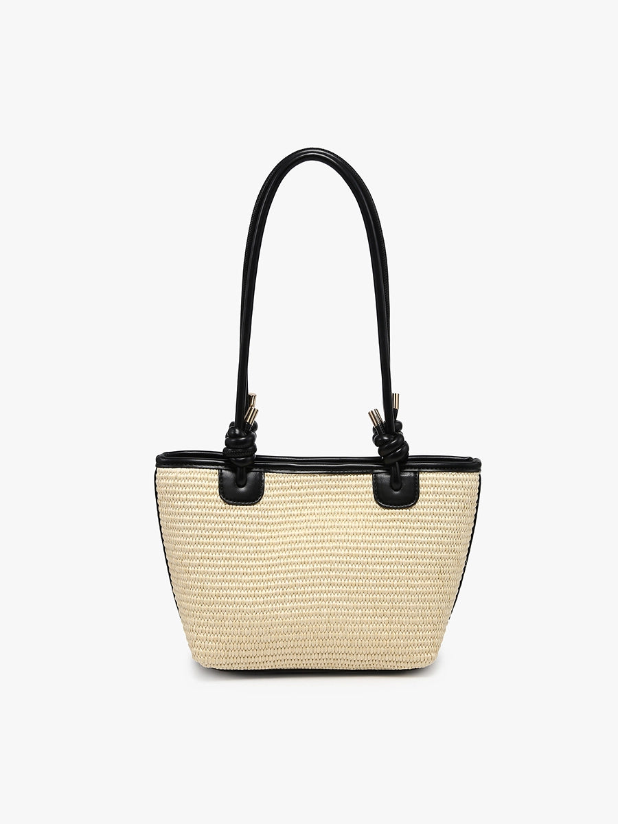 Beige straw handbag with black accents and black shoulder strap close-up