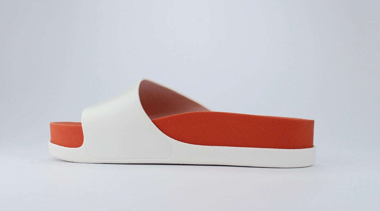 White sandal with a red sole inside