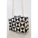 Black and white geometric patterned handbag with gold chain strap closeup