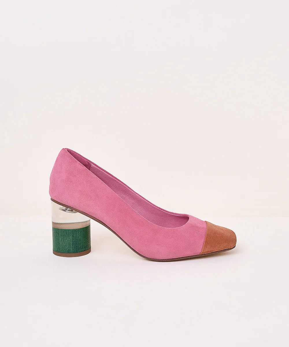 A pink suede pump with a pointed toe in brown leather and a chunky block heel featuring a green textured lower half, shown against a plain off-white background.