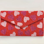 Red clutch bag with beaded heart pattern close-up