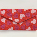 Red clutch bag with beaded heart pattern close-up