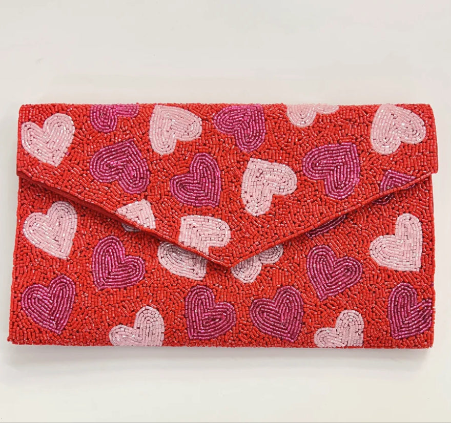 Red clutch bag with beaded heart pattern close-up