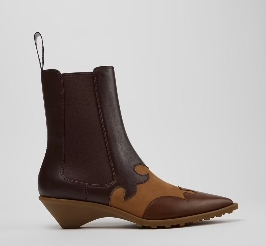 A dark brown and tan leather ankle boot with a wedge heel, elastic side gore, and pull loop, shown from a side profile 