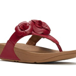 Red sandal with floral design and copper heel close-up