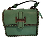 Green handbag with braided details closeup