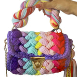 Colorful woven handbag with a braided handle closeup