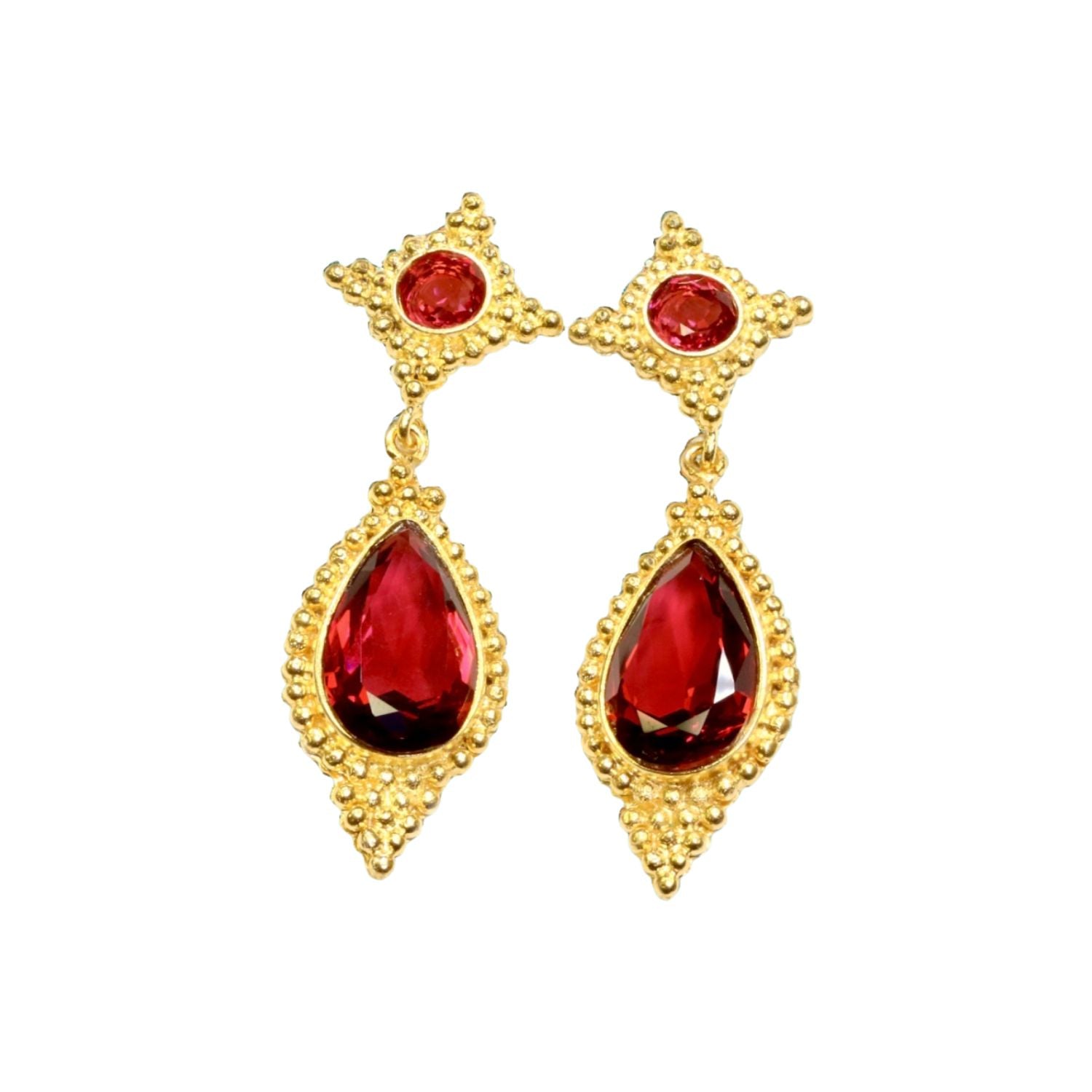Gold colored earrings with red stones on a white background