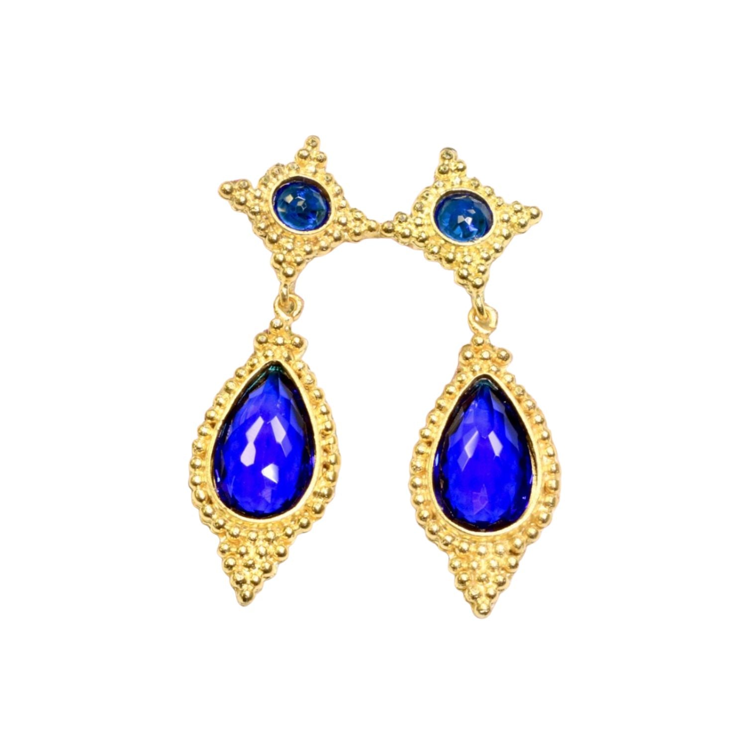 Gold colored earrings with blue teardrop stones on a white background
