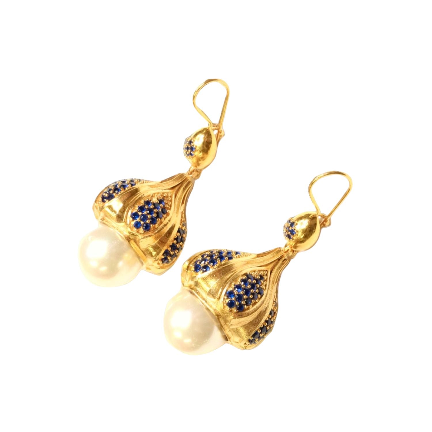 Gold colored earrings with pearl like accent and blue crystals on a white background