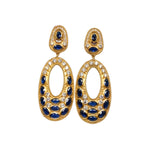 Gold colored earrings with dark blue and white crystal accents on a white background