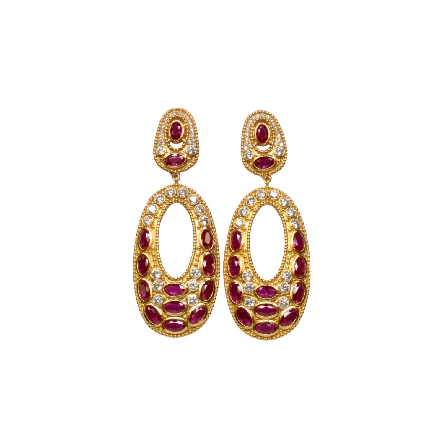 Gold colored earrings with dark magenta and white crystal accents on a white background