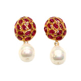 Pair of earrings with dark magenta crystals and pearl like drop accents on a white background