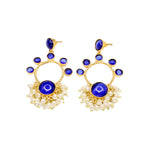 Gold hoop earrings with blue circular stones and pearl-like accents on a white background
