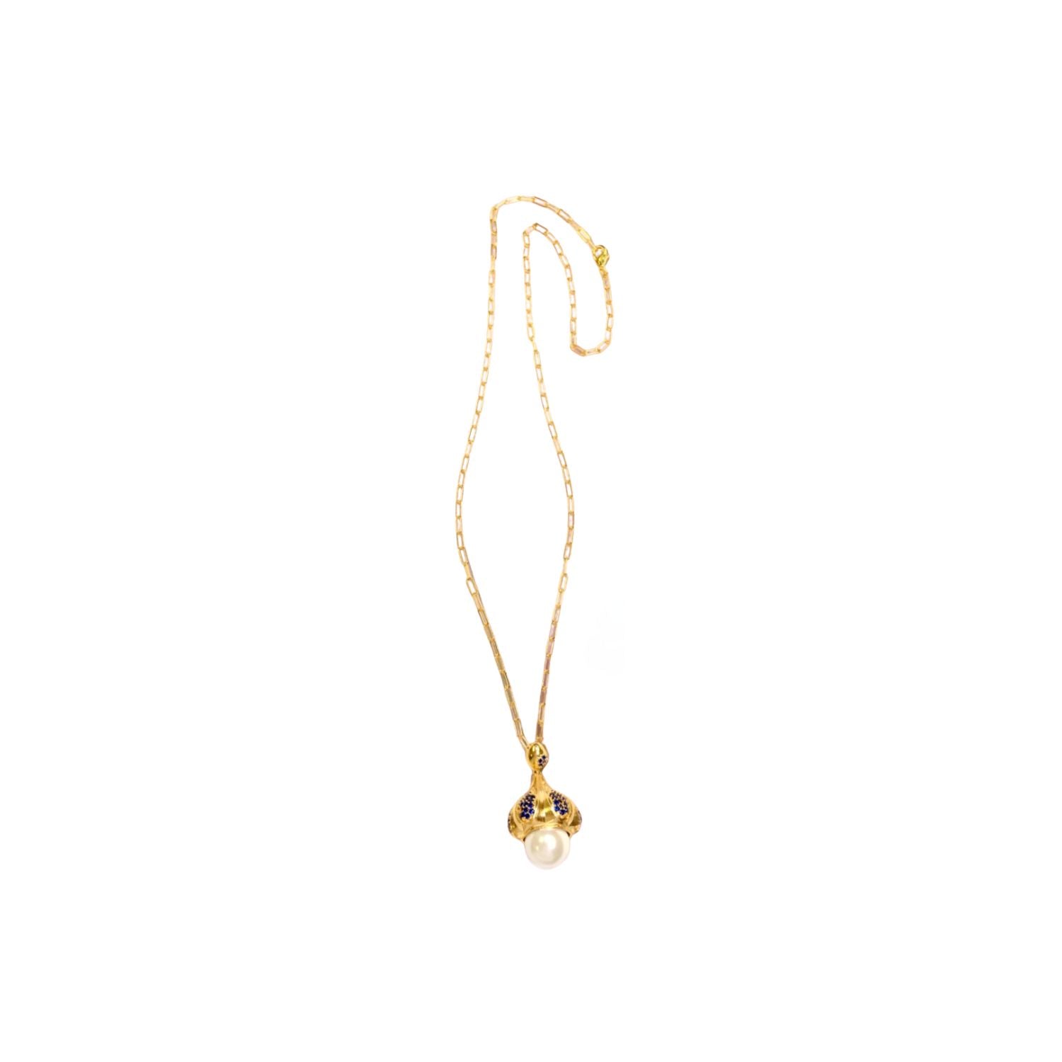 Gold colored necklace with a pearl like pendant and blue stone accents on a chain on a white background
