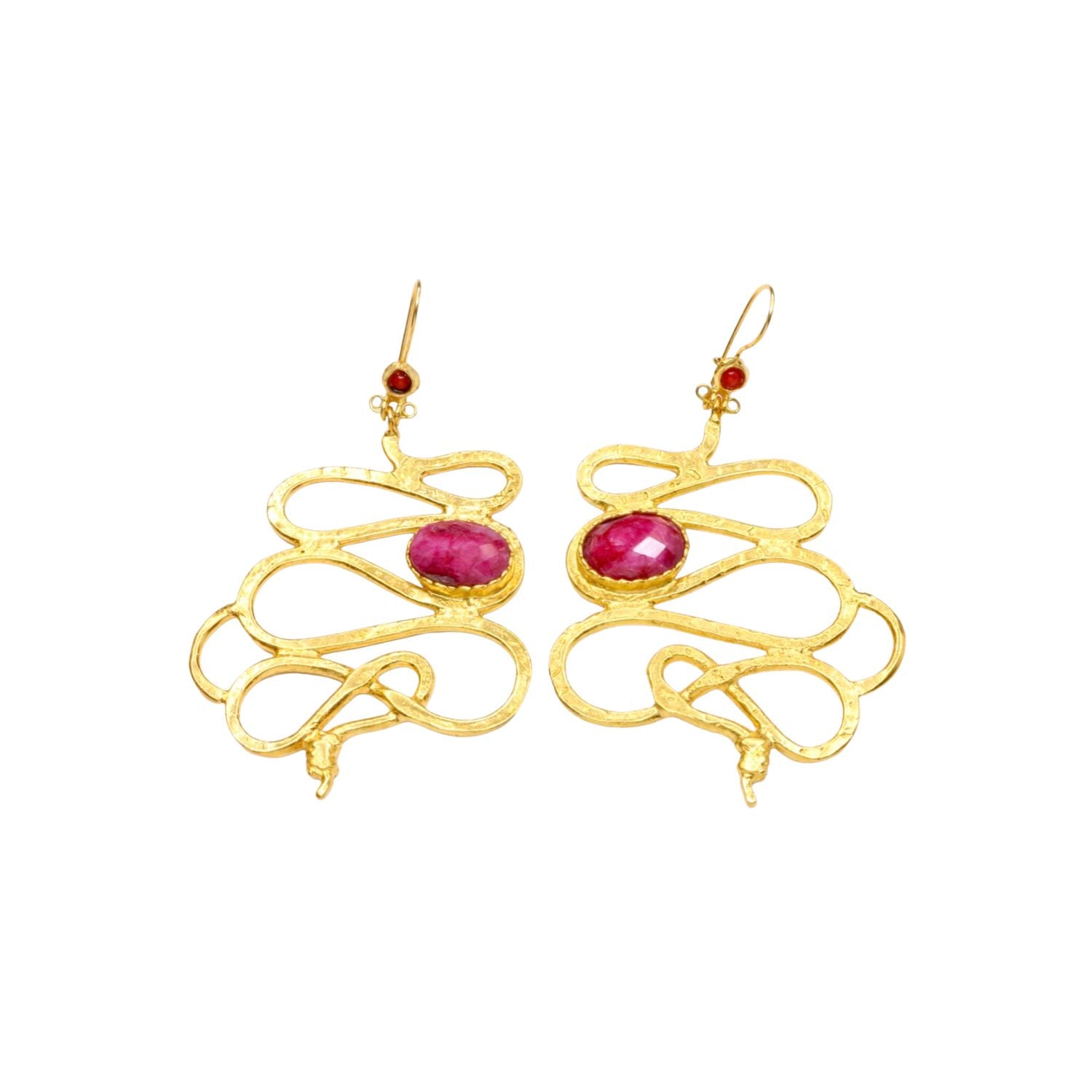 Gold colored snake shaped earrings with dark magenta stones on a white background